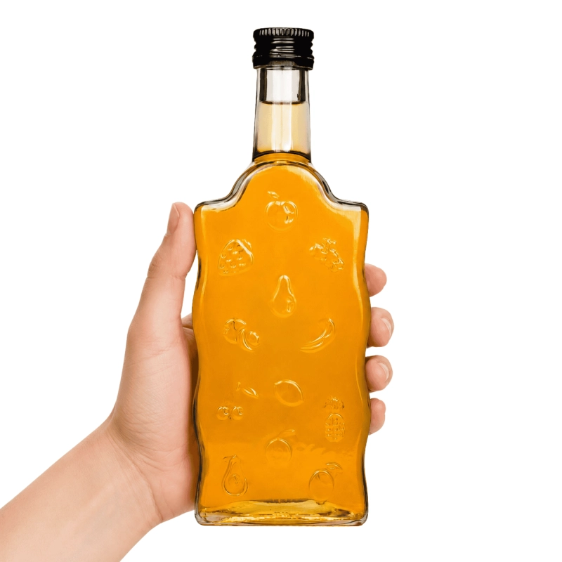 Szklana butelka Warta Fruit 500 ml w dłoni — widok proporcji, falowany bok i gwint fi 28 mm