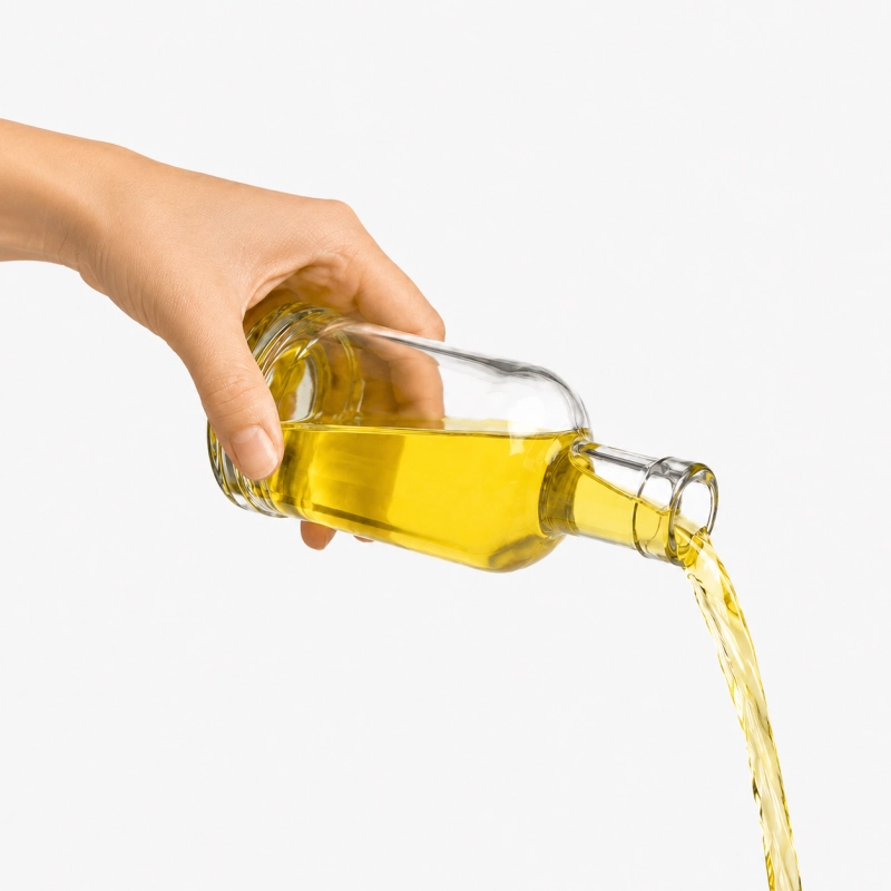 Dłoń nalewa złocisty likier ze szklanej butelki Tadek 250 ml, poręczna flaszka z zestawu 5 sztuk