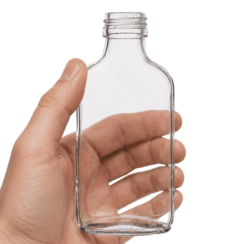 Pusta płaska piersiówka 100 ml trzymana w dłoni, kieszonkowa butelka z opakowania zbiorczego 20 szt