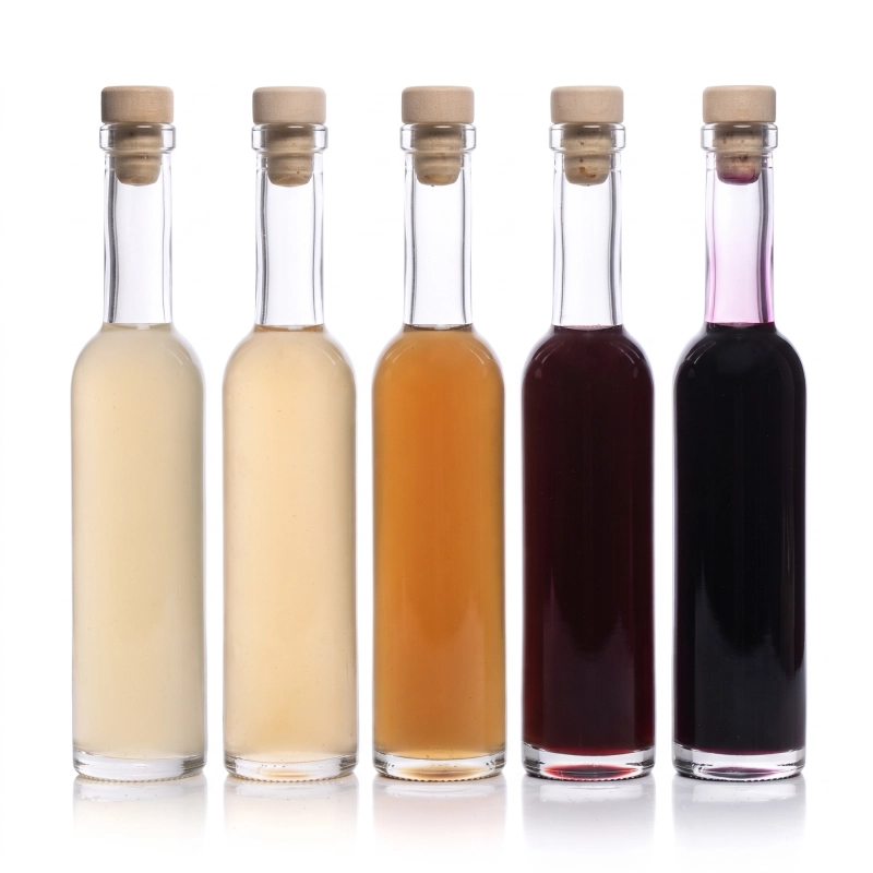 10 butelek szklanych Futura 100 ml z różnokolorowymi nalewkami ustawionych w rzędzie, komplet 10 sztuk